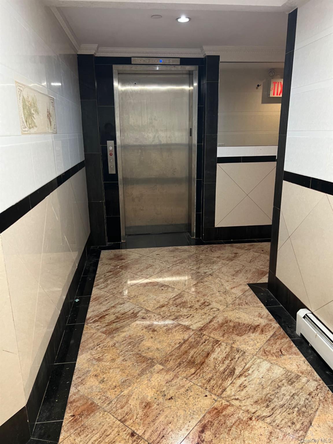 Hall featuring tile walls, elevator, a baseboard radiator, recessed lighting, and crown molding
