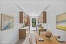 Sleek kitchen featuring wood-finish cabinetry, light-toned countertops, and a stainless steel refrigerator