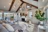 Living room with high vaulted ceiling, beamed ceiling, a fireplace, and wood finished floors