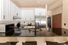 Kitchen with tasteful backsplash, white cabinets, appliances with stainless steel finishes, under cabinet range hood, and a breakfast bar area