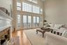 Living room with a healthy amount of sunlight, a high ceiling, french doors, a fireplace, and light hardwood / wood-style floors