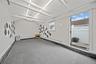 Carpeted spare room with beam ceiling and split ac and heat