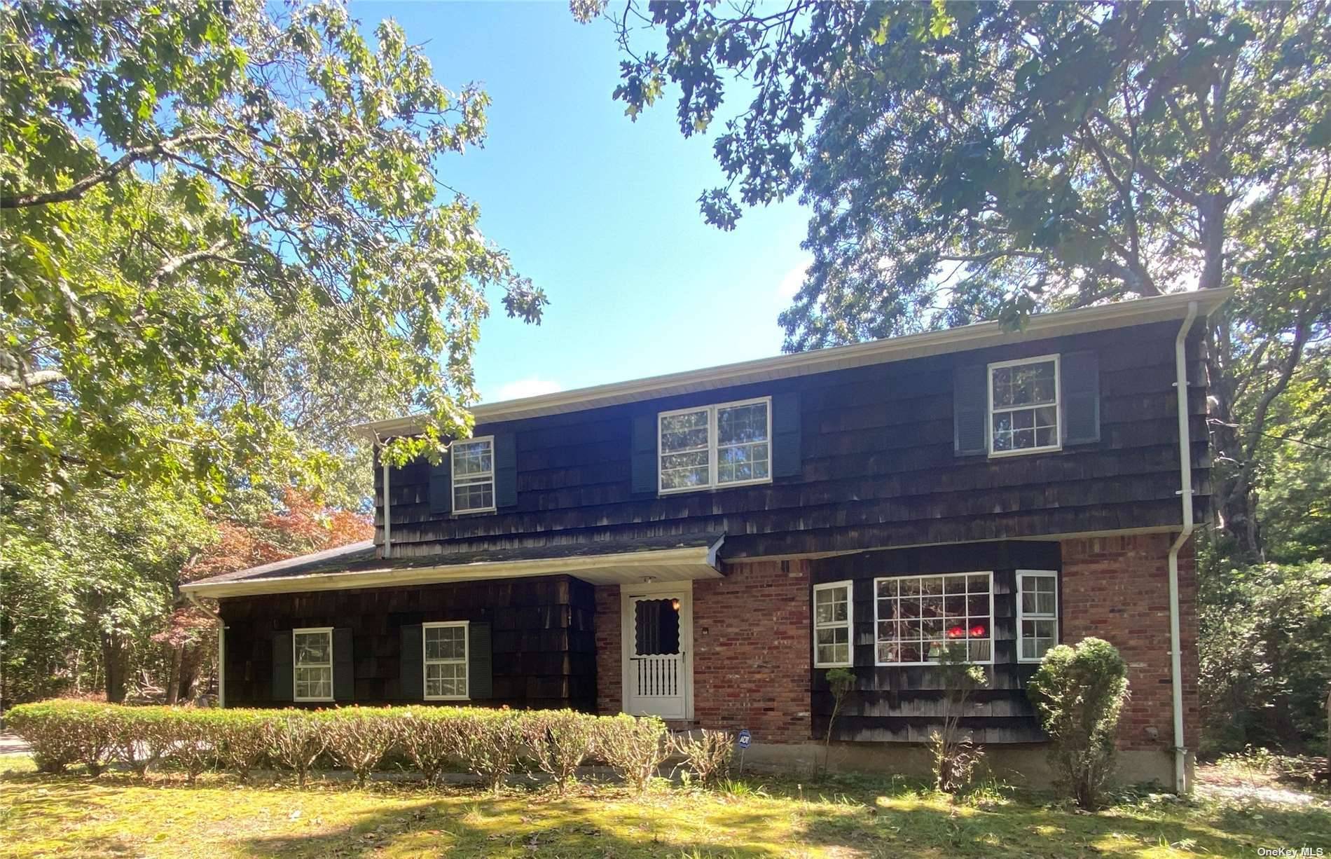 Quality built custom 1970 colonial on a wooded acre in Manorville.