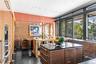 Kitchen featuring a center island, dark stone counters, dark brown cabinets, and sink