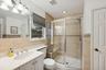 Bathroom with vanity, toilet, a shower with door, and tile walls