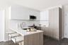 Kitchen with appliances with stainless steel finishes, white cabinetry, dark hardwood / wood-style flooring, a kitchen breakfast bar, and kitchen peni