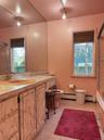 Full bathroom featuring track lighting, tiled shower / bath combo, vanity, and baseboard heating