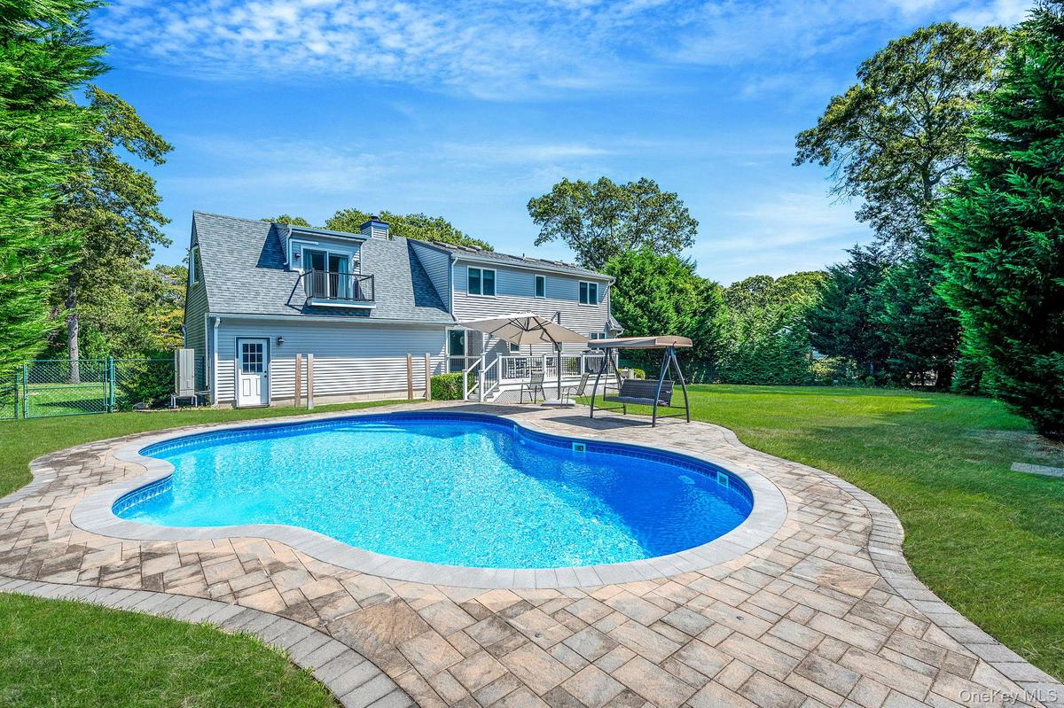 View of pool with a patio area and view of scattered trees