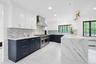 The stunning chef's kitchen has been completely renovated with quartz countertops, custom cabinetry, and premium appliances, including a Wolf six-burn