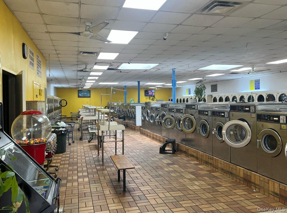 Community laundry with washing machine and dryer and brick patterned flooring