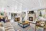 Living area with a glass covered fireplace, wood finished floors, and wooden ceiling