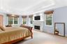 Bedroom featuring a fireplace, carpet floors, and a raised ceiling