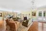 Living room featuring a chandelier, a warm lit fireplace, healthy amount of natural light, and french doors