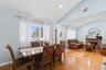 Dining area featuring light wood-type flooring, healthy amount of natural light, a stone fireplace, recessed lighting, and high vaulted ceiling