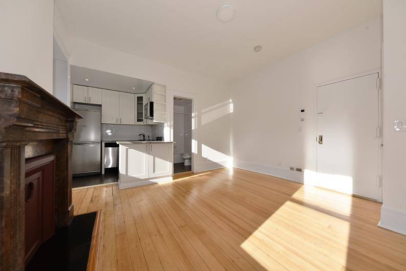 Beautiful, sunny one bedroom featuring modern kitchen and bath while still maintaining original details like wide planked wood floors, decorative fireplace, and moldings throughout.