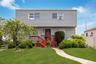 Two-story residence featuring light gray siding and a red-stained wood deck