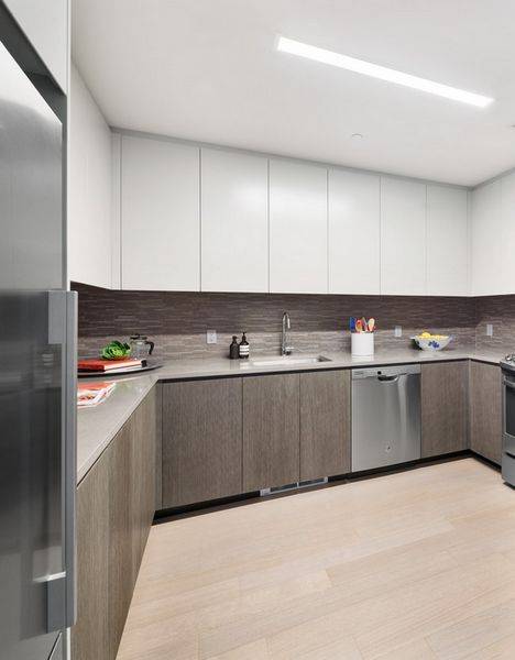 Spacious studio apartment featuring an over sized u shaped kitchen with loads of counter and cabinet space, stainless steel appliances, and quartz countertops.