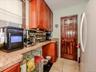 Kitchen area featuring warm-toned cabinetry, and light tile flooring