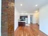 Kitchen with appliances with stainless steel finishes, light wood-type flooring, light countertops, a peninsula, and open floor plan