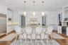 Kitchen featuring decorative backsplash, beverage cooler, glass insert cabinets, built in appliances, and a center island with sink
