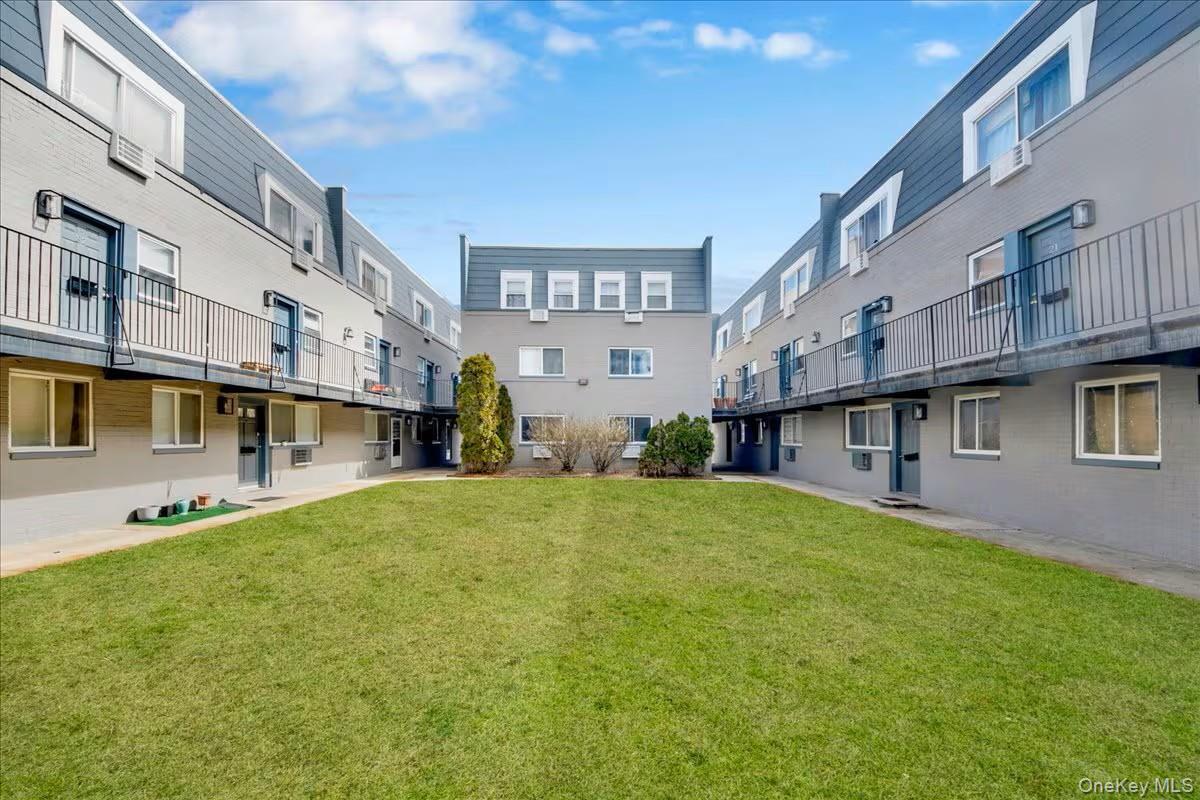 Central green space featuring a manicured lawn surrounded by multi-story residential buildings
