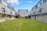 Central green space featuring a manicured lawn surrounded by multi-story residential buildings