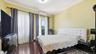 Bedroom with dark wood finished floors, crown molding, and a wall mounted AC