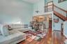 Living room with a towering ceiling, wood finished floors, and stairway