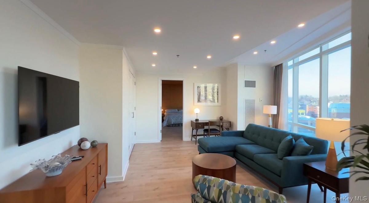 Living area featuring light wood-style flooring, recessed lighting, expansive windows, and crown molding