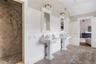 Full bath featuring a tile shower, lofted ceiling, tile patterned flooring, visible vents, and a decorative wall