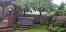 View of yard with a pergola, fence, a wooden deck, and a hot tub