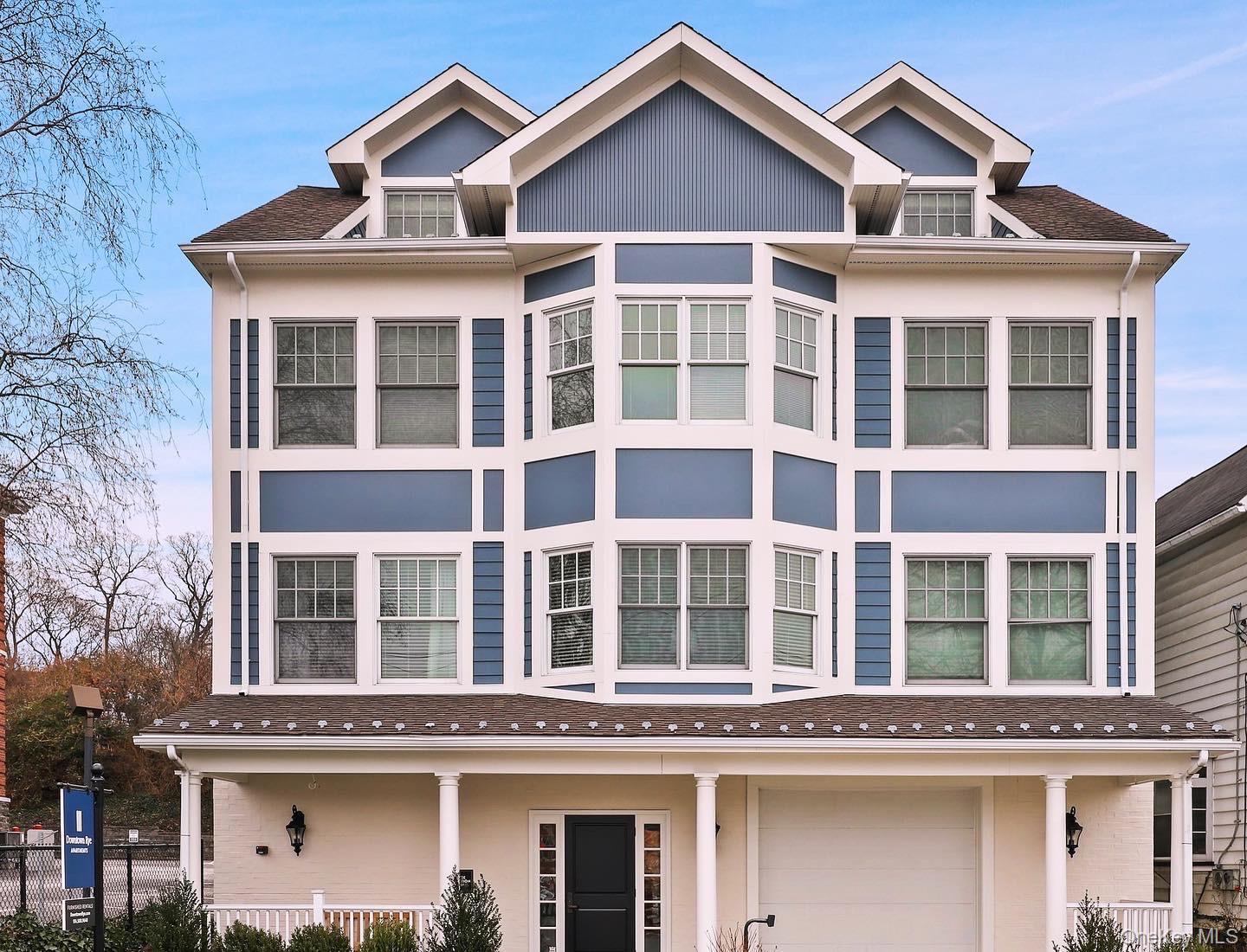 View of front of property with an attached garage, stucco siding, and a porch