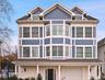 View of front of property with an attached garage, stucco siding, and a porch