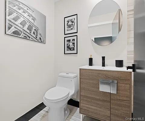 Half bathroom with vanity and toilet