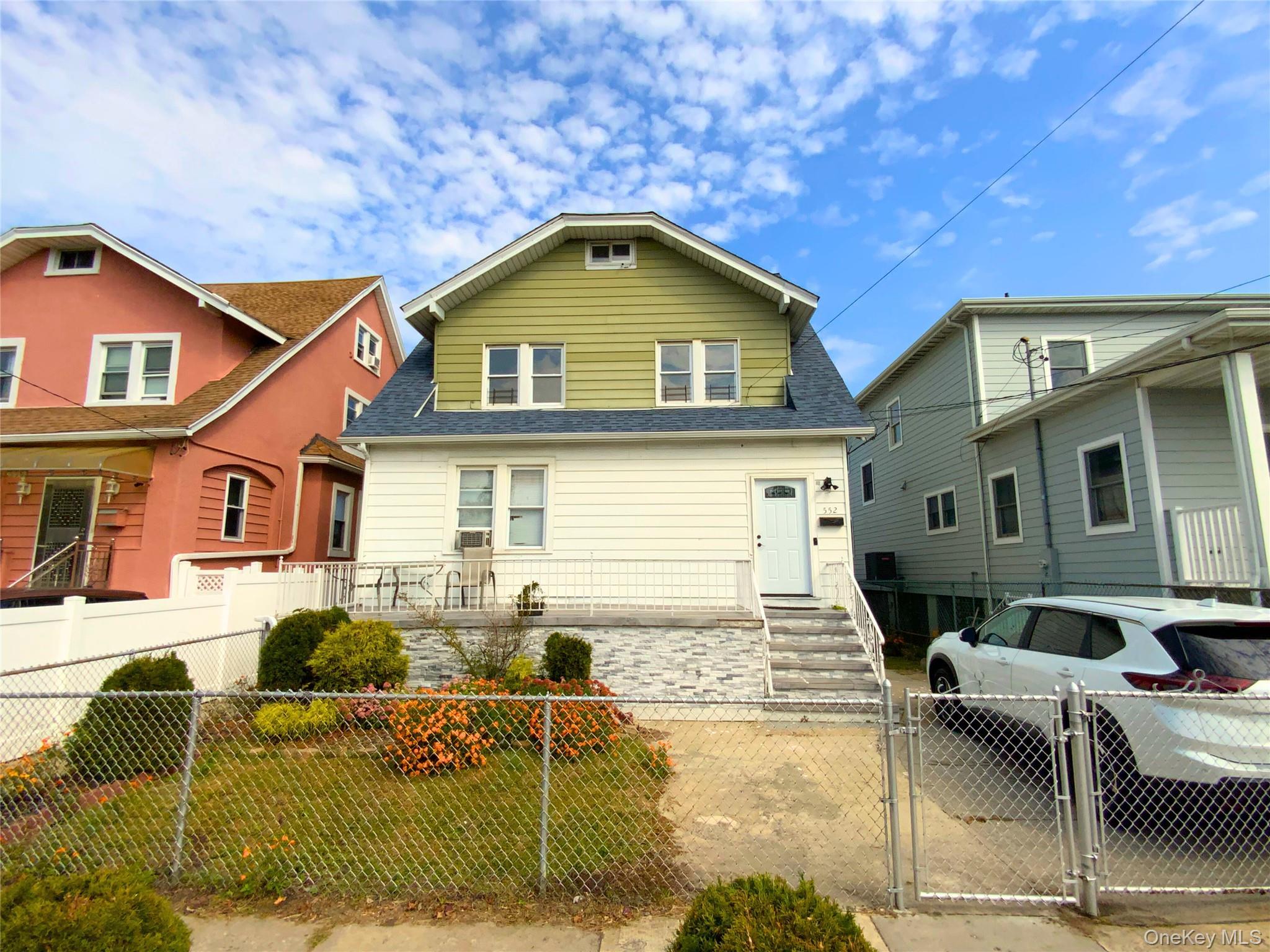 View of front of home featuring a gate, a fenced front yard, and roof with shingles