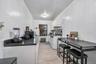 Kitchen featuring gas range gas stove, white cabinets, radiator, light wood-type flooring, and under cabinet range hood