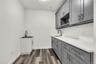 Laundry room with dark wood-type flooring and baseboards