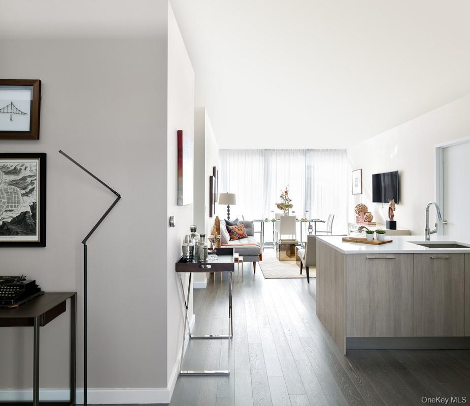 Kitchen with dark wood-type flooring, kitchen peninsula, and sink