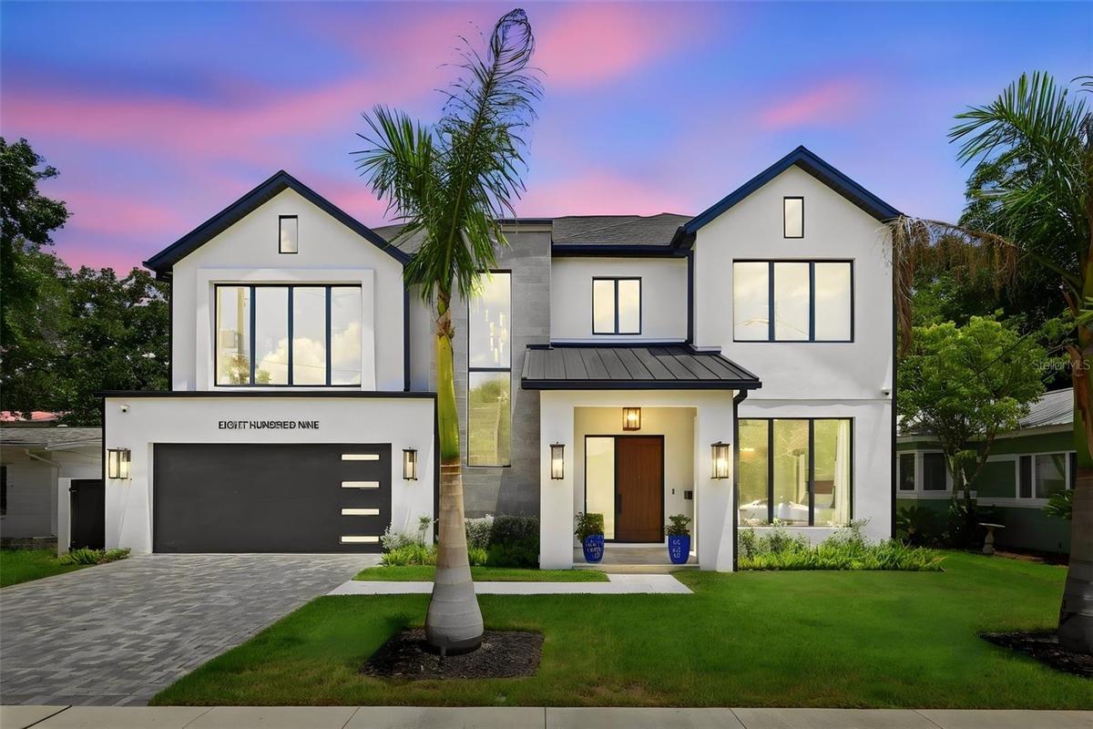The roof combines architectural shingles with standing-seam metal accents