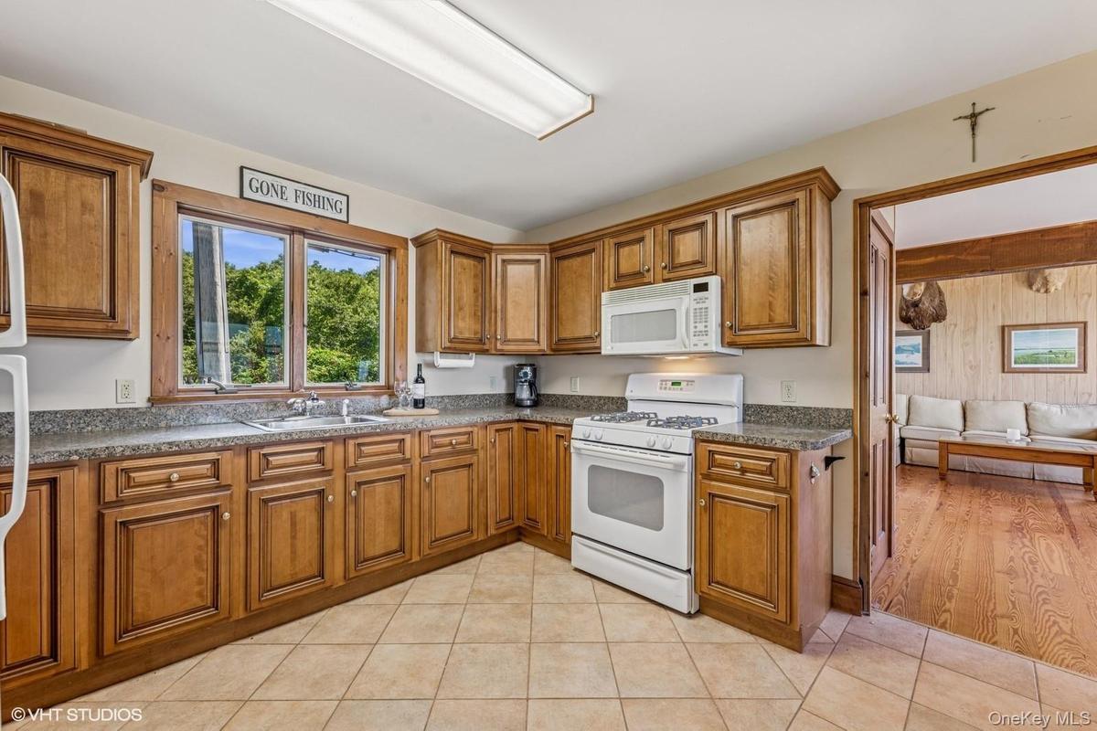 Kitchen with white appliances, brown cabinets, and light tile patterned floors