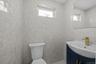Half bathroom with vanity and tile walls
