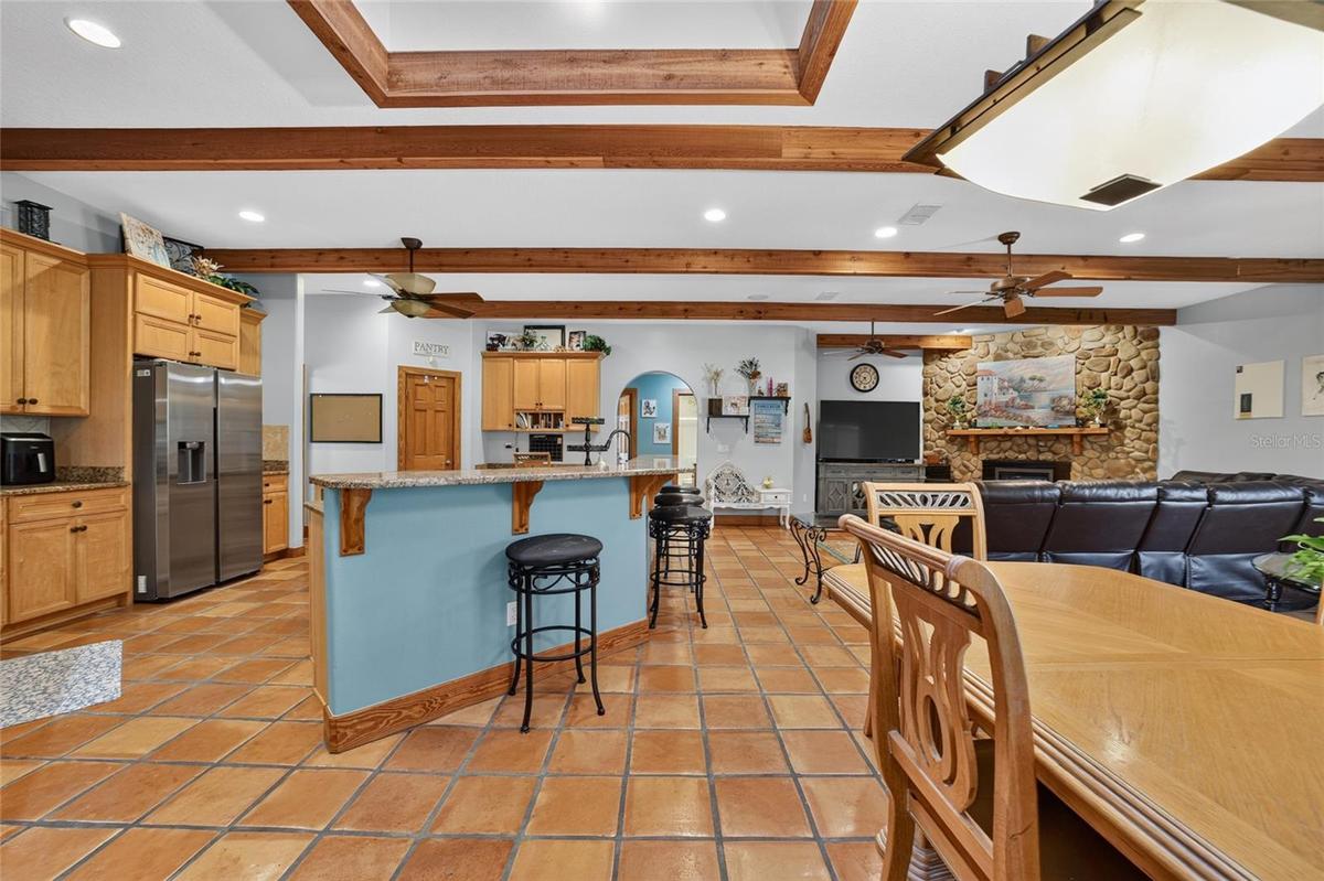 Open-Concept Gourmet Kitchen, Dining & Family Room with Exposed Wood Beams