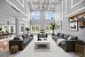 Living area featuring a chandelier, a high ceiling, wood finished floors, recessed lighting, and ornamental molding