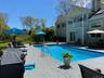 Swimming pool with a patio, outdoor dining space, a balcony, and a wooden deck