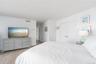Bedroom featuring wood finished floors, baseboards, and visible vents