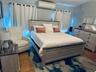 Bedroom featuring an AC wall unit and dark wood-style flooring