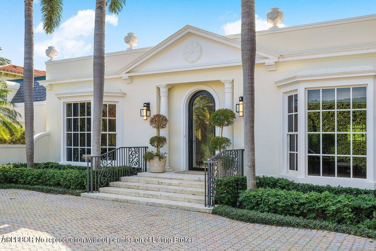 Welcome to the timeless elegance of Palm Beach Regency at this meticulously renovated 1959 Henry Harding designed estate.