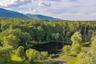 The estate’s spring-fed pond enjoys a peaceful setting framed by mature trees and the Catskill Mountains
