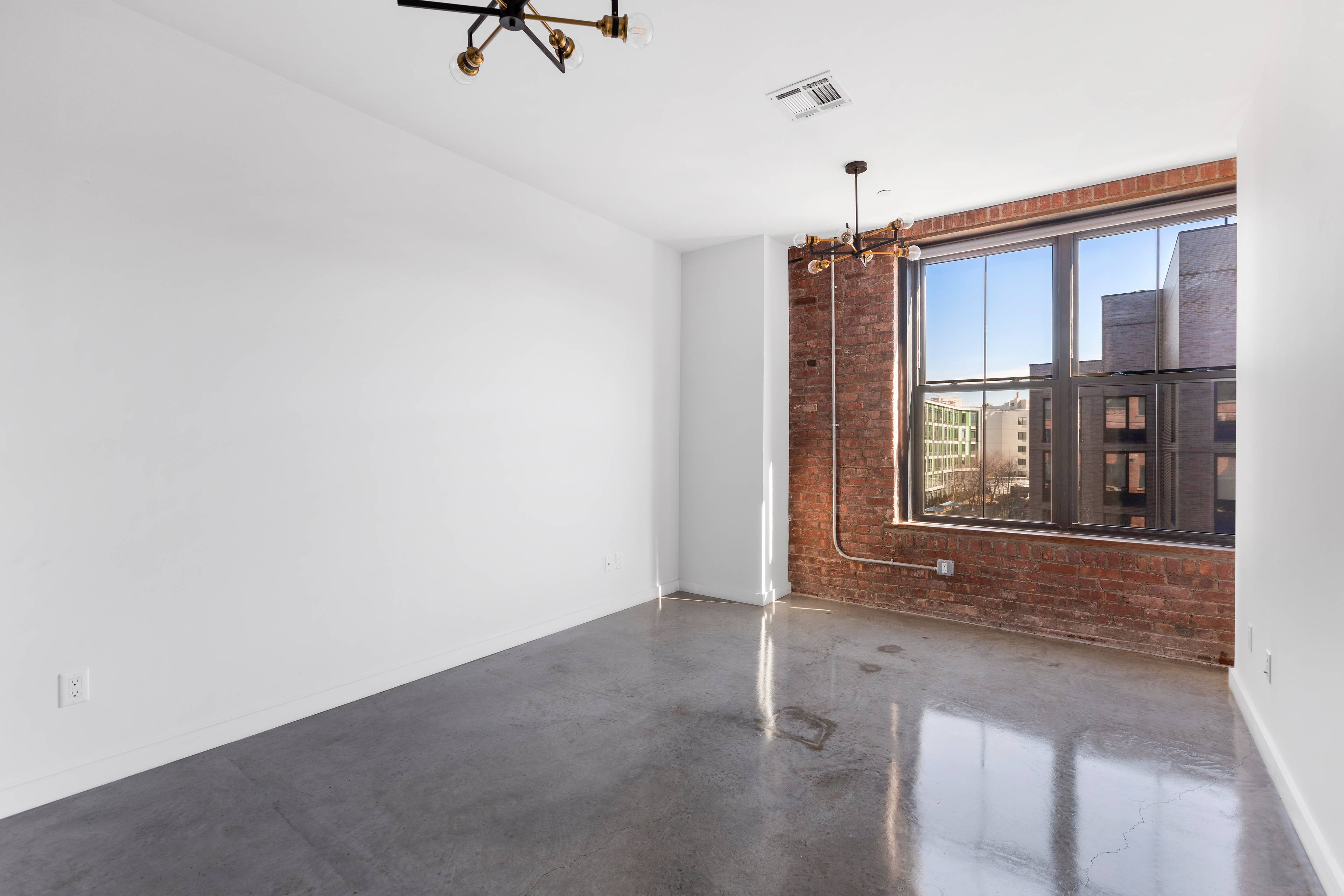 Loft 1B is a large one bedroom featuring high ceilings, exposed brick walls, and timber beams.