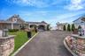 View of front of home featuring asphalt driveway, a garage, roof with shingles, and a gate